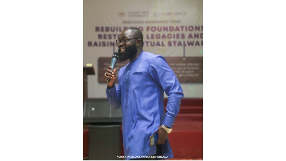 A speaker with a microphone addressing the VVUSSA Excellence Awards and Dinner 2022